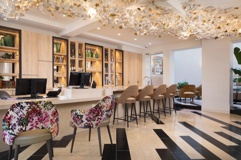 Stylish hotel bar with two flowered chairs and a black and white floor 