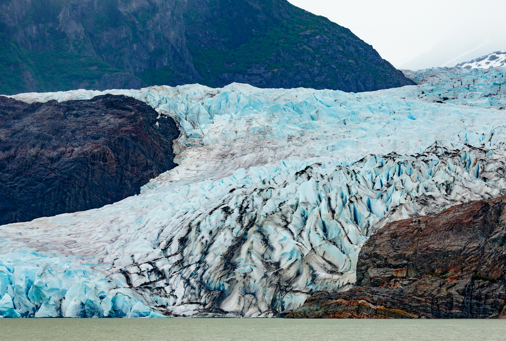 View across the water to the rugged and blue Mendenhall Glacier, one of the best places to visit in Alaska.