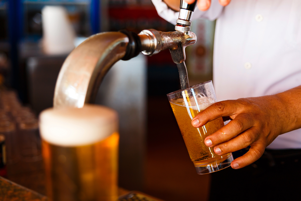 Draft beer pour in a glass from the crane in an article about the best bars in Shoreditch. 