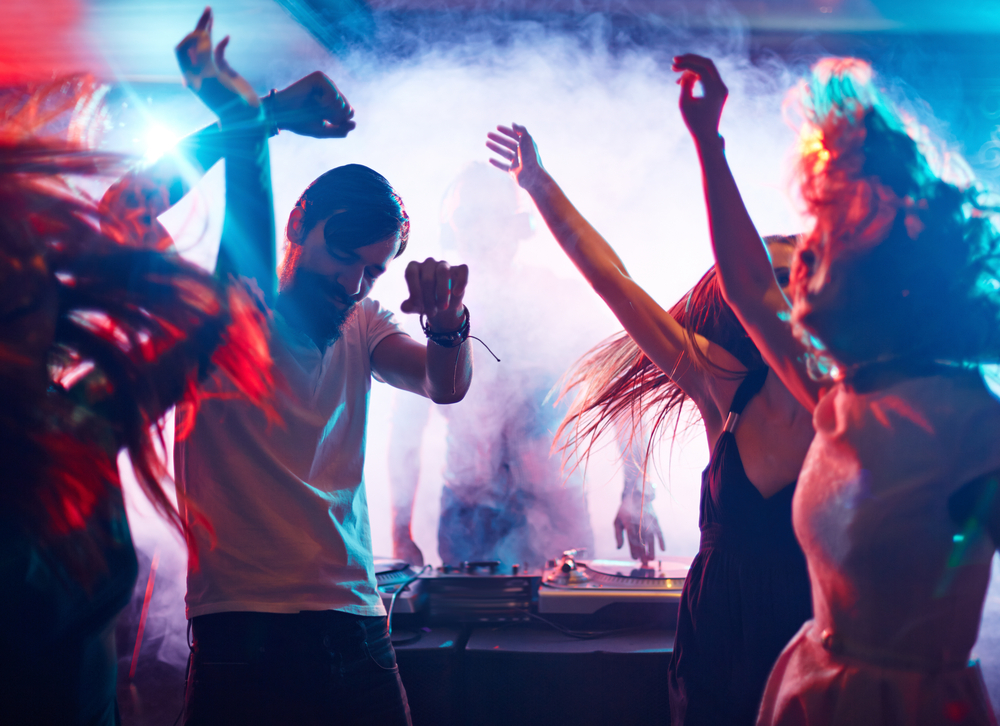 Male and females dancing with smoke in background at bar in shoreditch