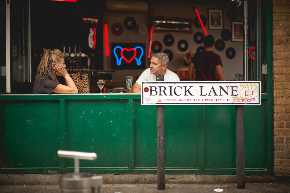  A couple having drinks in a bar in Brick Lane. The article is about the best bars in Shoreditch. 
