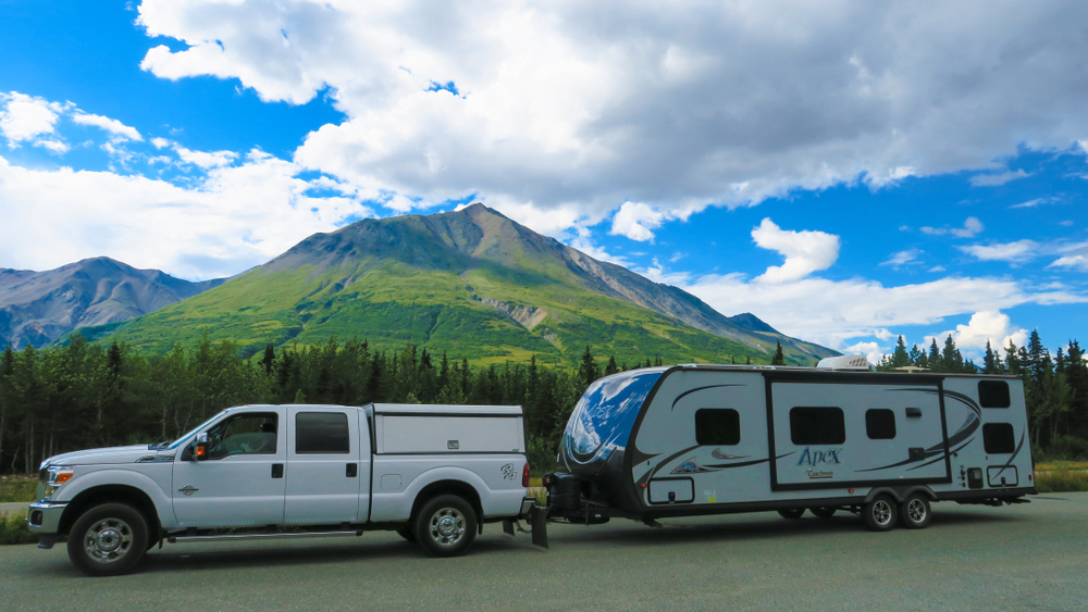 Van and caravan on the road boondocking. There are mountains in the background.  