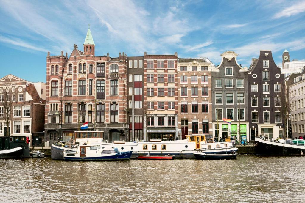 The view of the outside of a hotel that is several buildings connected in Amsterdam along the canal