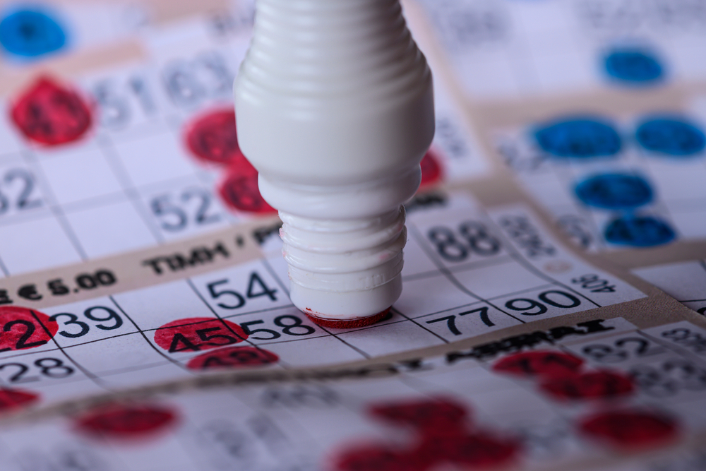 Playing Bingo. Marking numbers with red marker, close up.