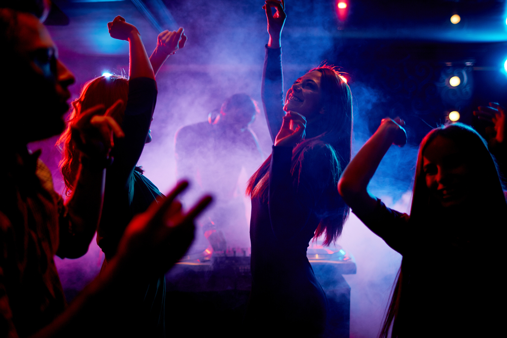 Group of dancing young people enjoying night in club. 