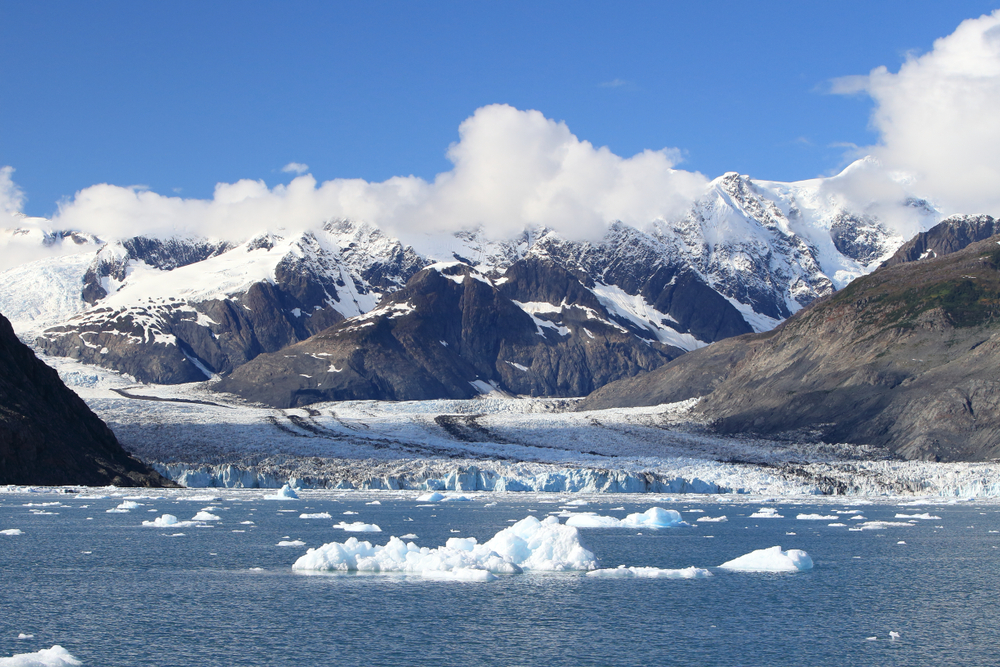 Sunny day at Columbia Glacier with many icebergs in the water.