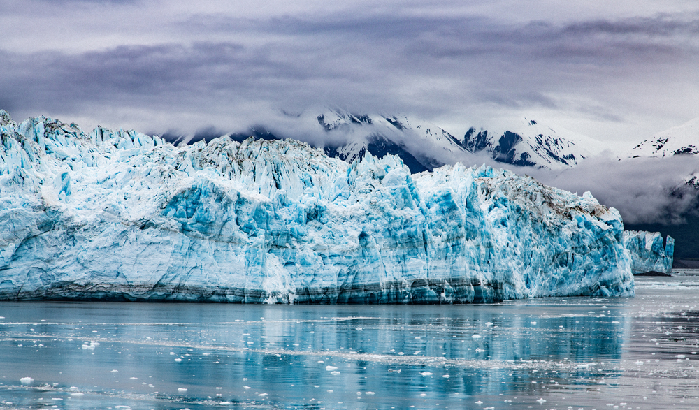 Cloudy day over the rugged Hubbard Glacier with tall ice walls.