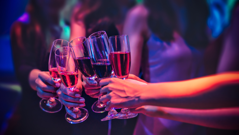 Group of female friends cheering with red wine in nightclub - Happy people drinking and having fun in nightclub - Party and nightlife concept - Focus on close up wine glass