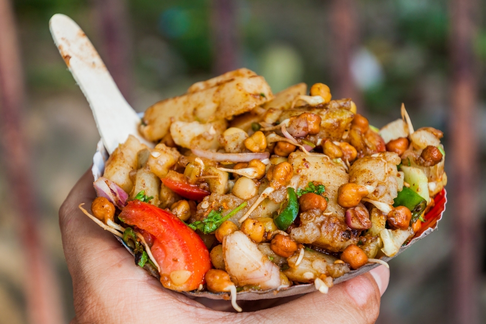 Chana Chaat held up in front of the camera with a spoon poking out. Indian food is so good in Covent Garden. 