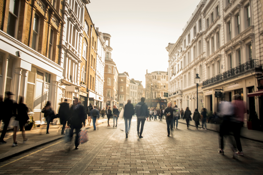 Motion blurred anonymous people on busy city shopping street