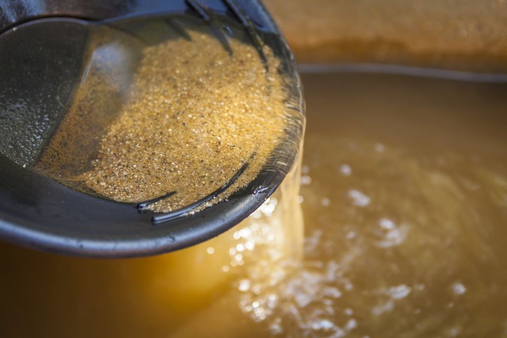 Close up of gold panning pan with sifting sand.