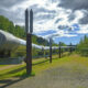 Large silver pipeline elevated above ground with blue sky & clouds in background. on of the best things to do in Fairbanks Alaska
