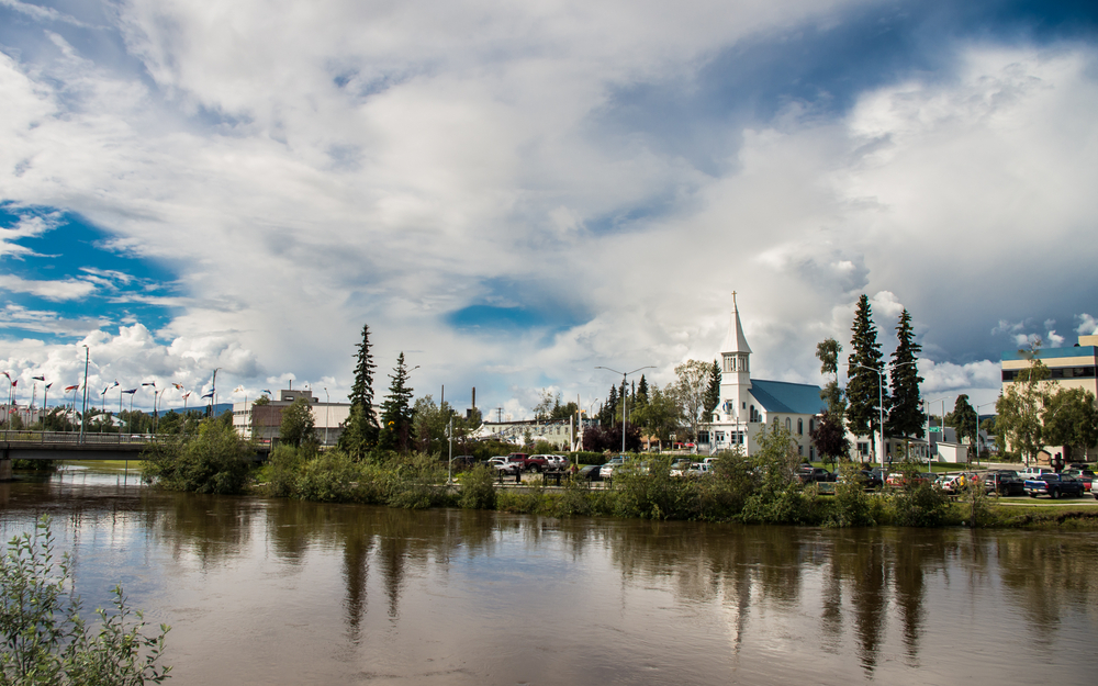 Scenery of Fairbanks city downtown over Chena river. The photo shows a church and building in an article about things to do in Fairbanks. 