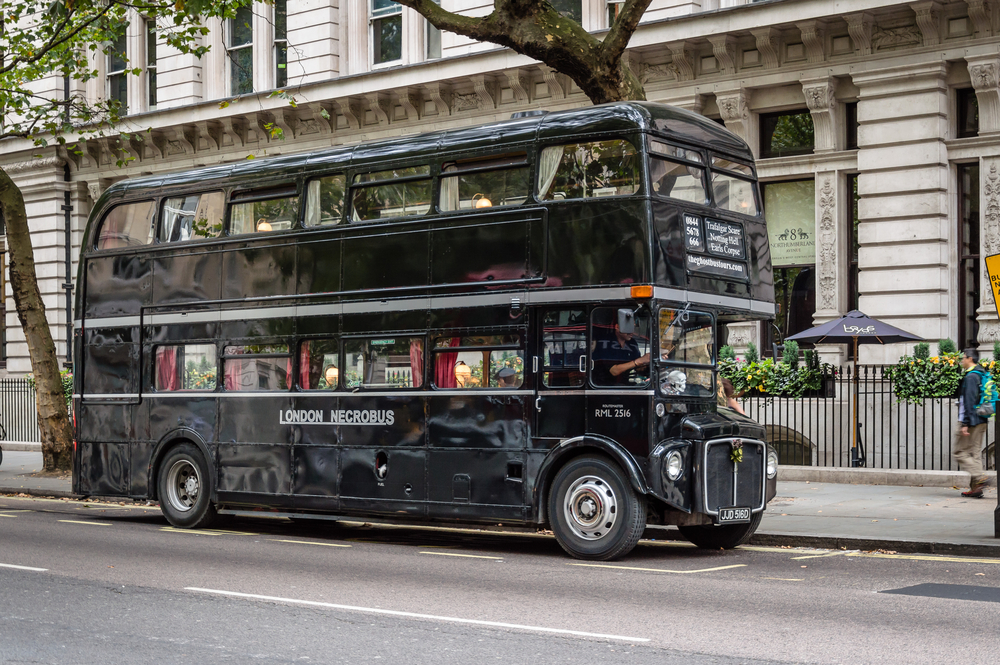 Classic Routermaster bus painted in black for touristic tours, parked in a street of London. The bus is used for ghost tours in London 