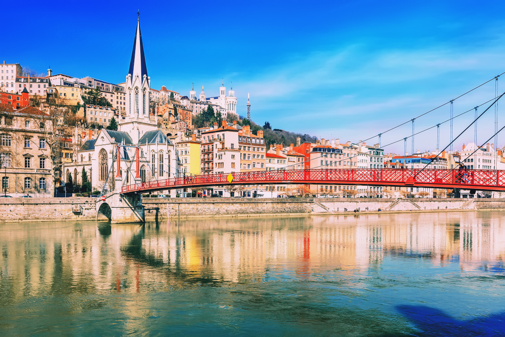 View across the river showing a footbridge and church on the riverfront in Lyon.