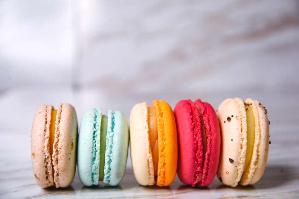A row of colorful macarons on a countertop.