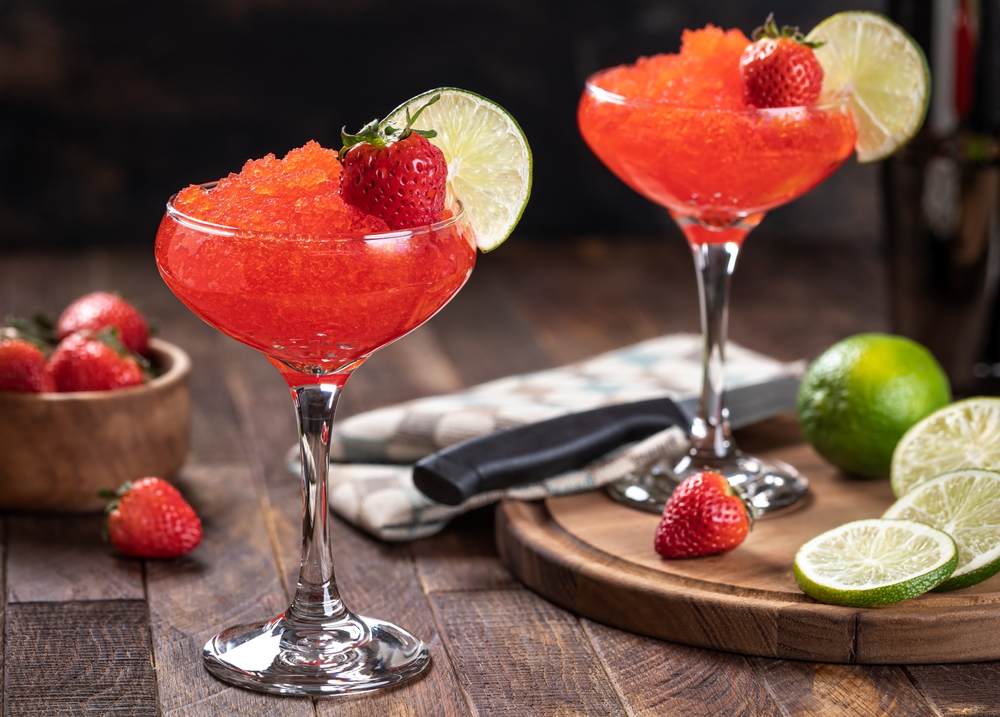 Tasty looking frozen strawberry daiquiris with fresh fruit.