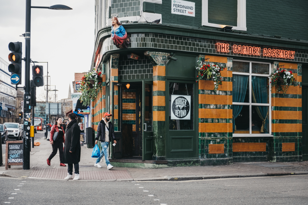 Exterior of the Camden Assembly with people walking by in London.