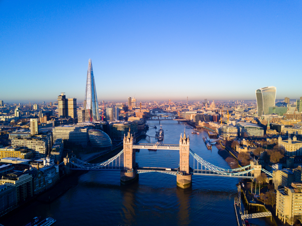 Aerial view over Tower Bridge, River Thames and the city of London. The article is about the best walks in London. 