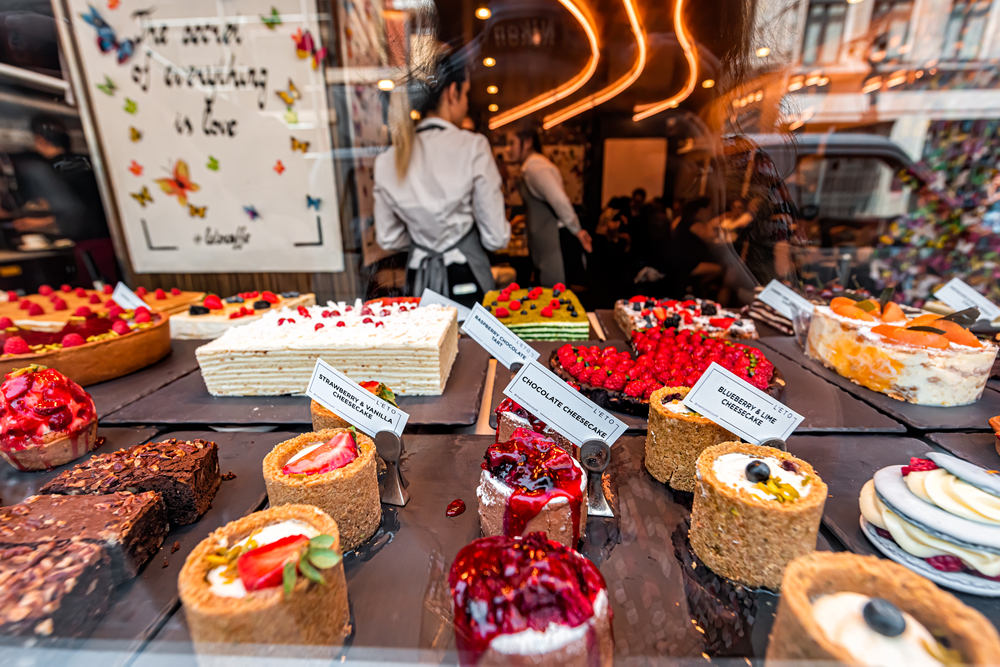  L'Eto bakery cafe and restaurant with retail display looking through window with selection of chocolate, lime and strawberry cake cheesecakes in