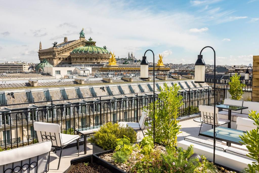 A modern sleek bar with white charis and a view over Paris. 