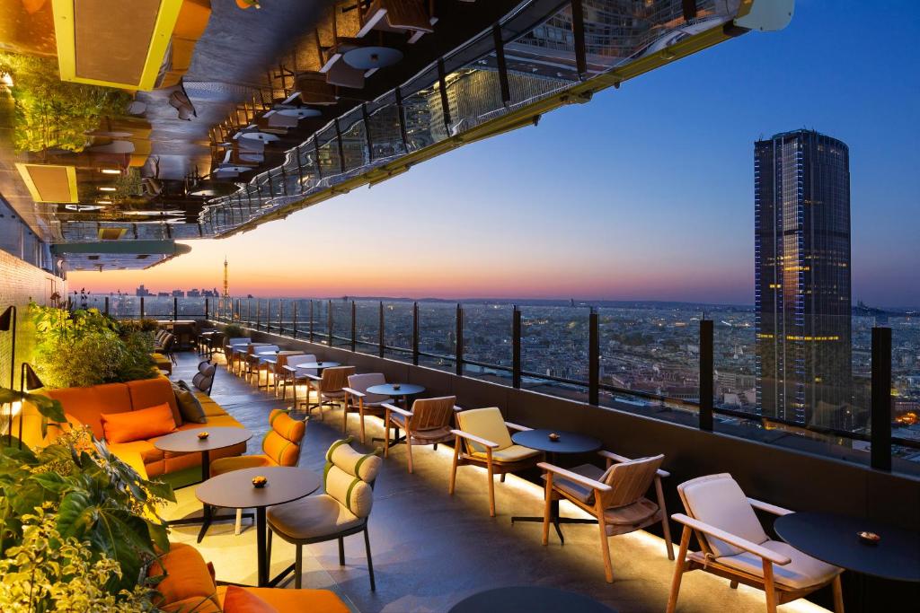 The terrace of skybar one of the rooftop bars in Paris. You can see tables and chairs and the view. 