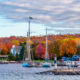 Brightly colored leaves in background with sailboats moored in blue water in foreground at romantic getaways in the Midwest