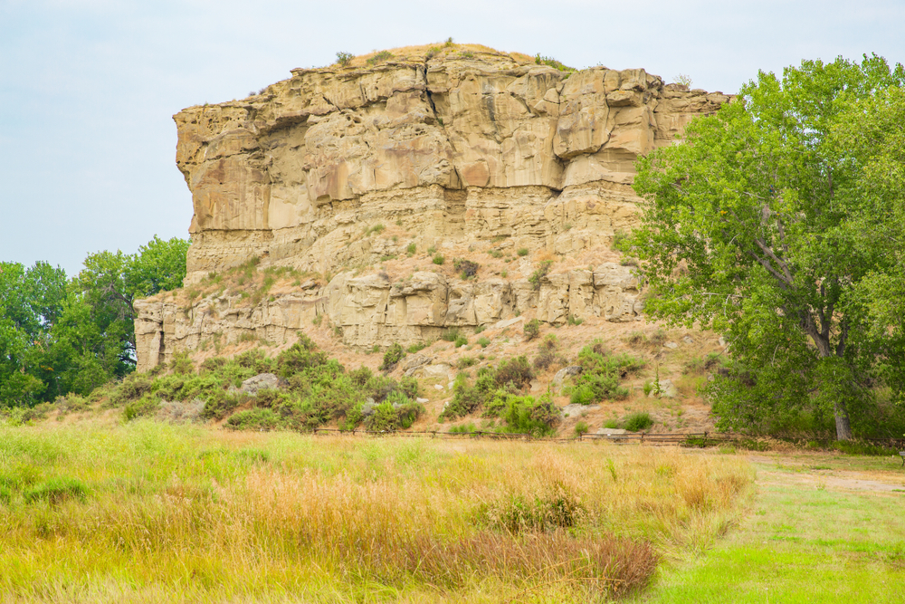 Pompeys Pillar National Monument, Lewis and Clark Trail, Montana, USA. You can see a large rock with trees around. 