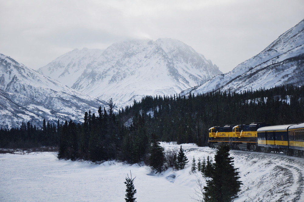 Train going through the snowy mountains in Alaska.