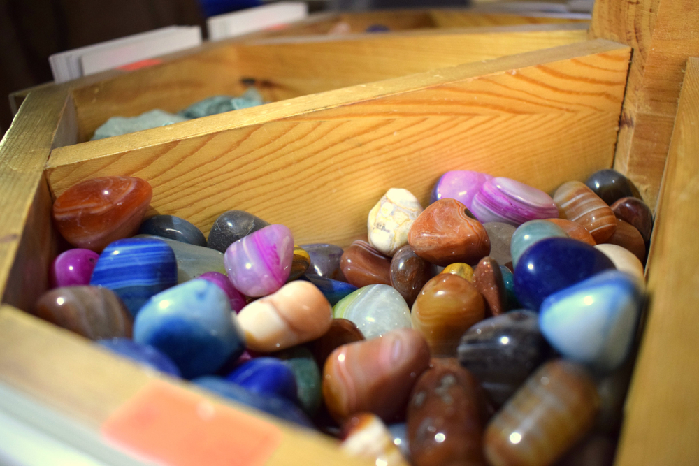 A wooden box full of polished gem stones