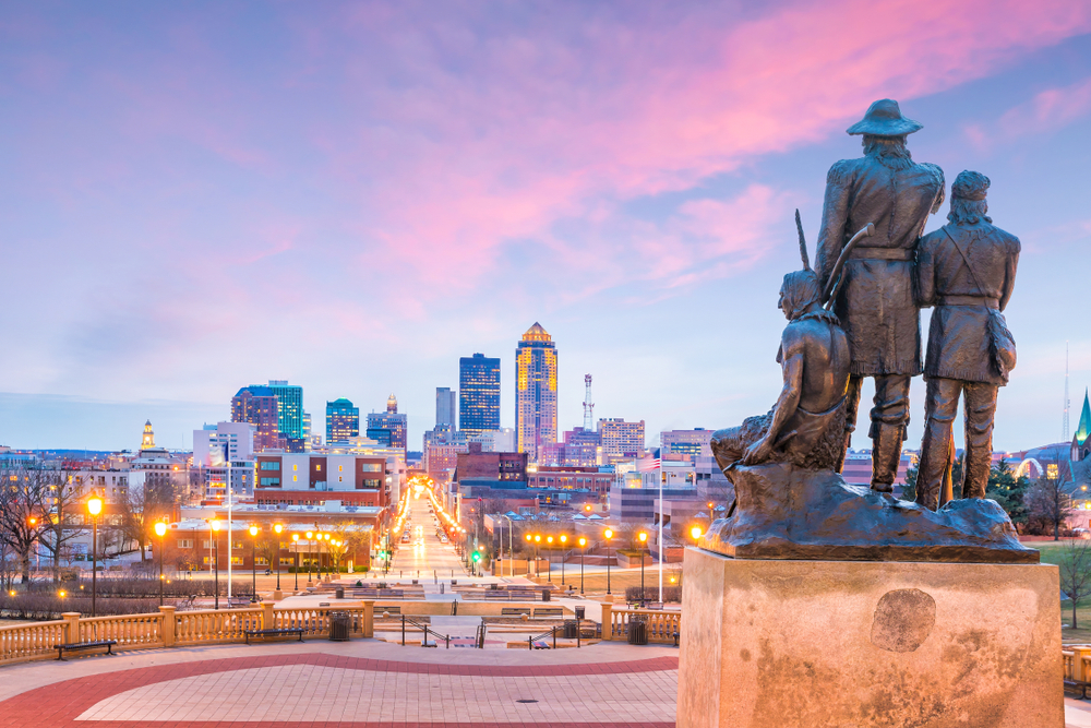 Des Moines Iowa skyline in USA with The Pioneer of the former territory statue. There is a sunset in the background.