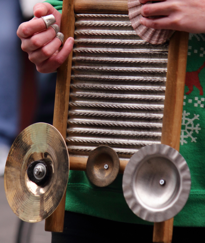 A person playing a washboard that has been turned into an instrument