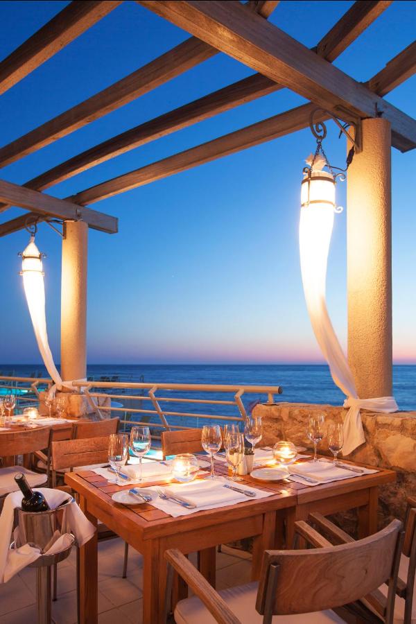 Outdoor dining area overlooking the sunset over the sea at the Hotel Dubrovnik Palace.