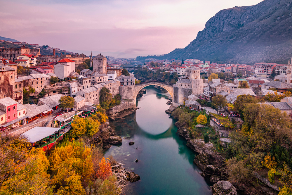 Panoramic view of Mostar at dusk featuring the Old Bridge.