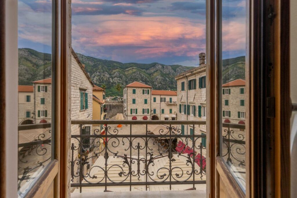 View of vivid sunset over Old Town Kotor through a hotel window.