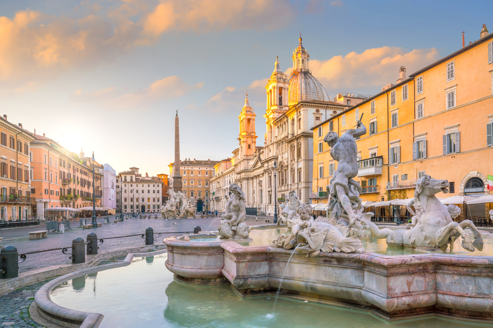 Sunrise at Piazza Navona featuring a fountain with statues.