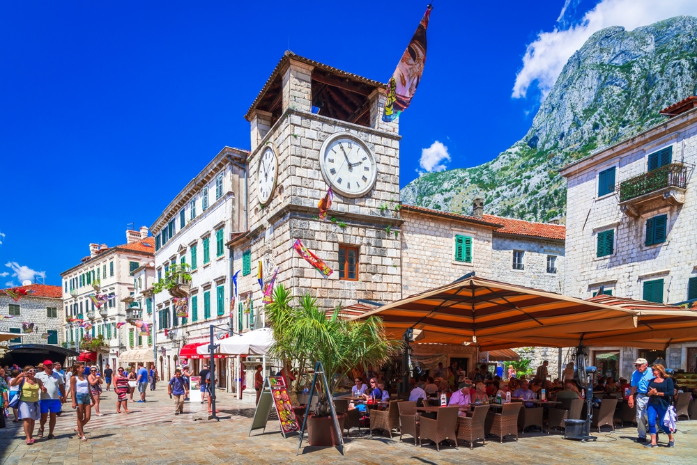 People shopping and dining in the Piazza of Arms next to the Kotor Clock Tower.