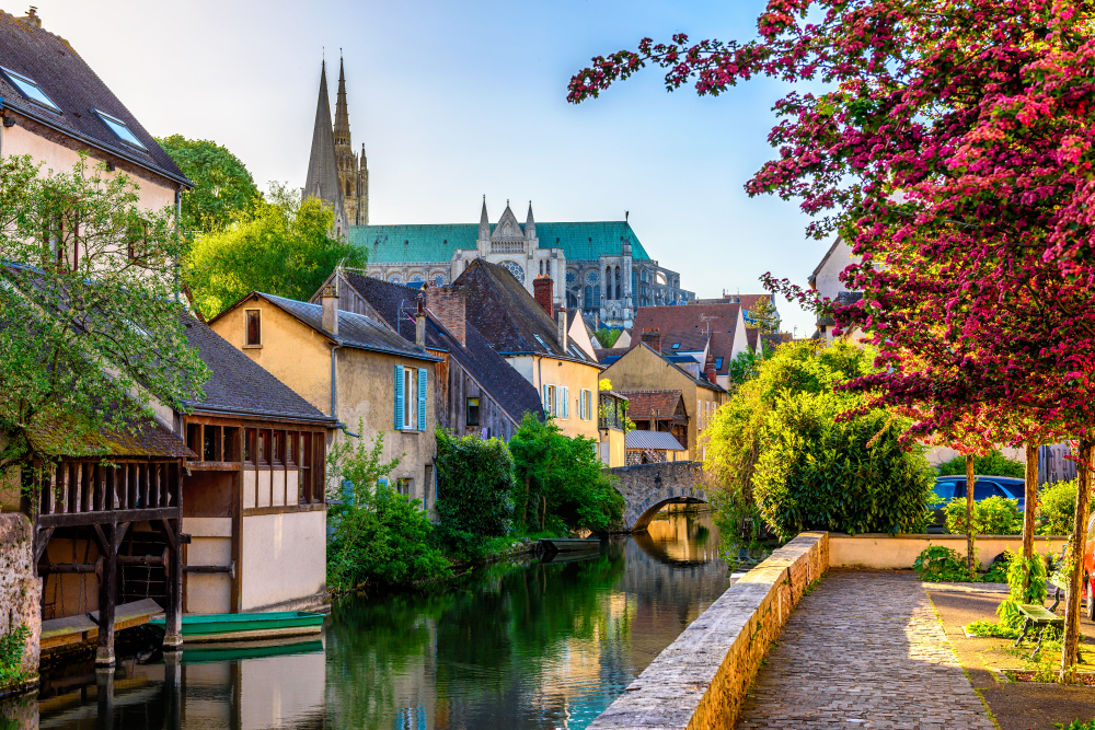 Eure River embankment with old houses and Notre-Dame de Chartres Cathedral in a small town Chartres. One of the day trips from Paris by train