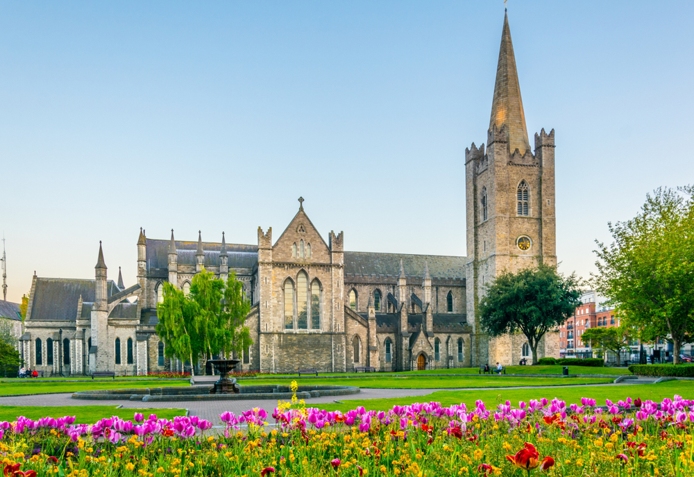 View of the St. Patrick's Cathedral in Dublin, Ireland. There are flowers out the front. 