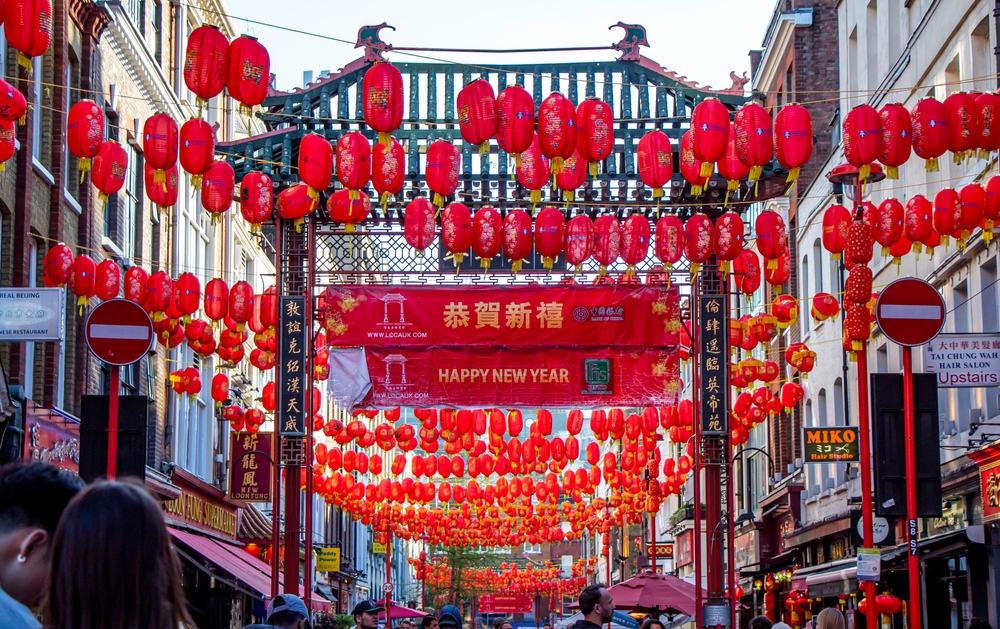 Bright red paper lanterns strung over a street in Chinatown in London.