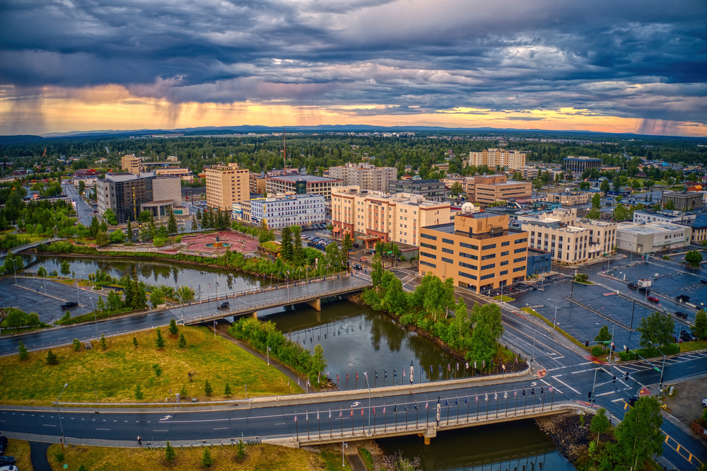 Aerial view of sunset over the city of Fairbanks with the river in the foreground and rain in the distance.