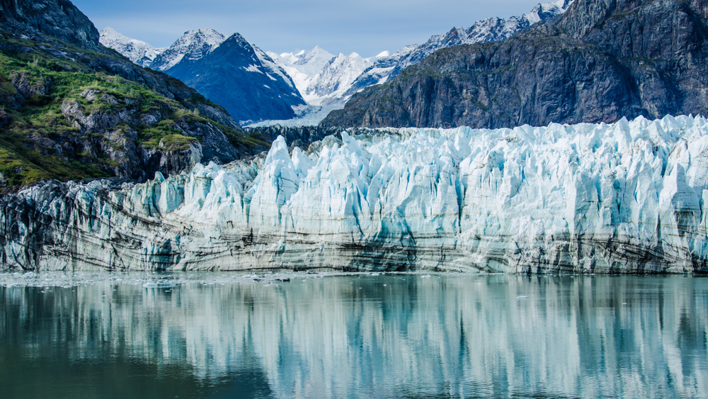 Beautiful, rugged Alaska glacier reflecting in the water in Glacier Bay National Park.