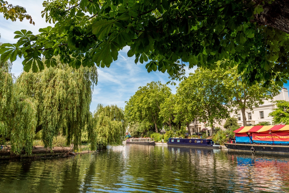 Canal with house boats and lined with trees in Little Venice.