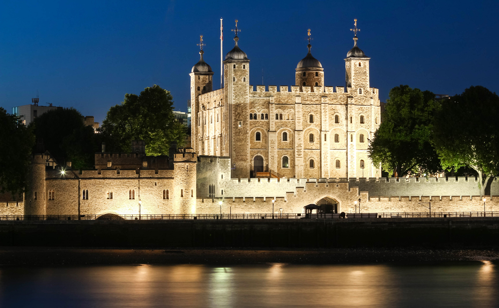 The Tower of London in the dark with lights on it. The article is about your first time in London. 