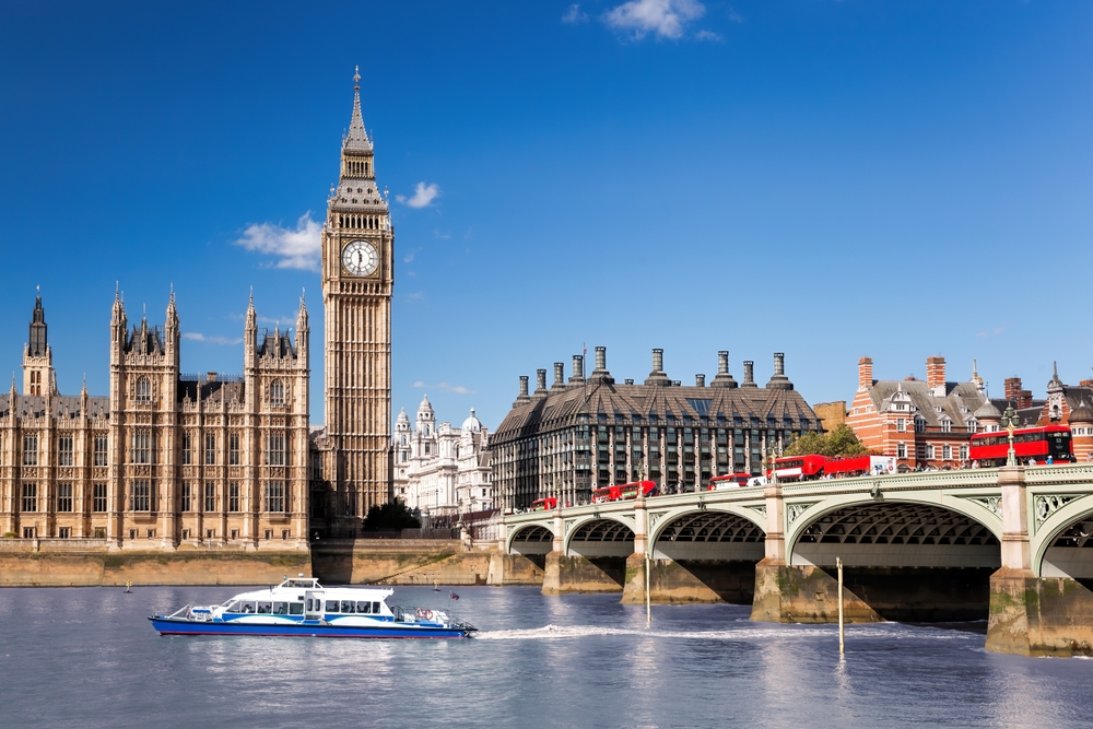 Famous Big Ben with bridge over Thames and tourboat on the river