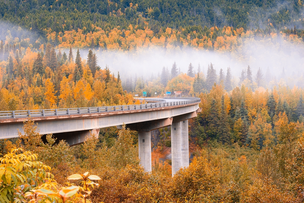Seward Highway near Canyon Creek Rest Area in fall season , Alaska. The road is raised up among the trees. 