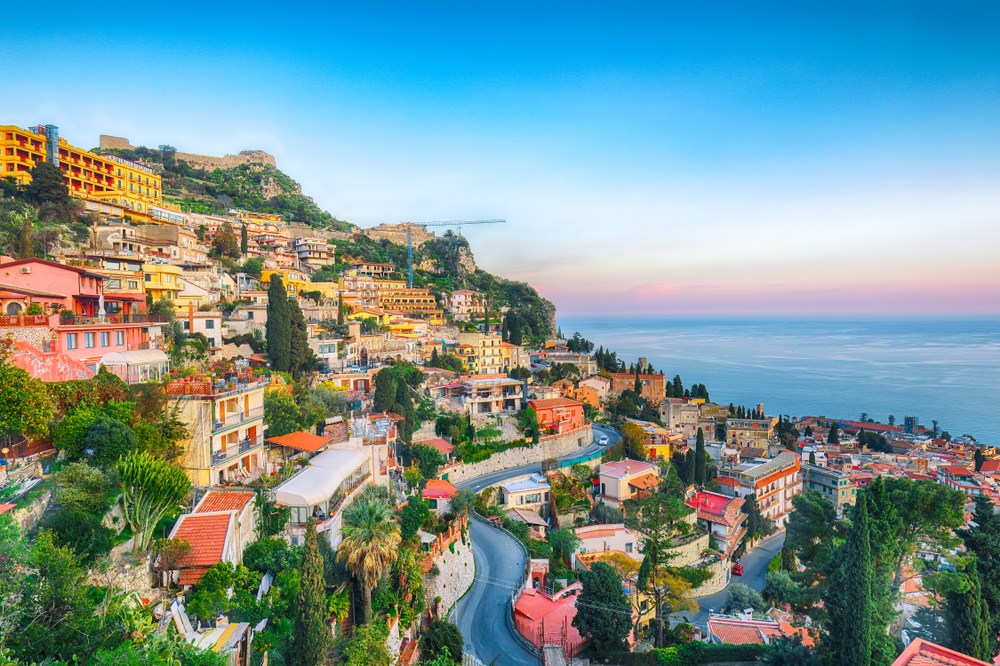 view of a coastal mountain town overlooking the sea things to do in taormina