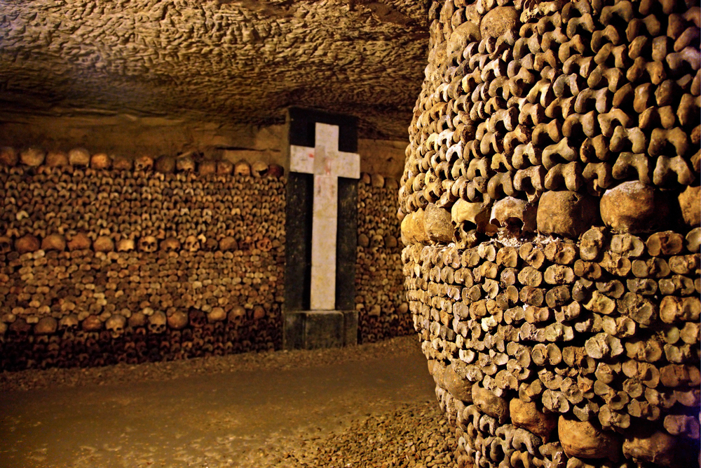A passage in the Paris Catacombs with walls made of bones and skulls.