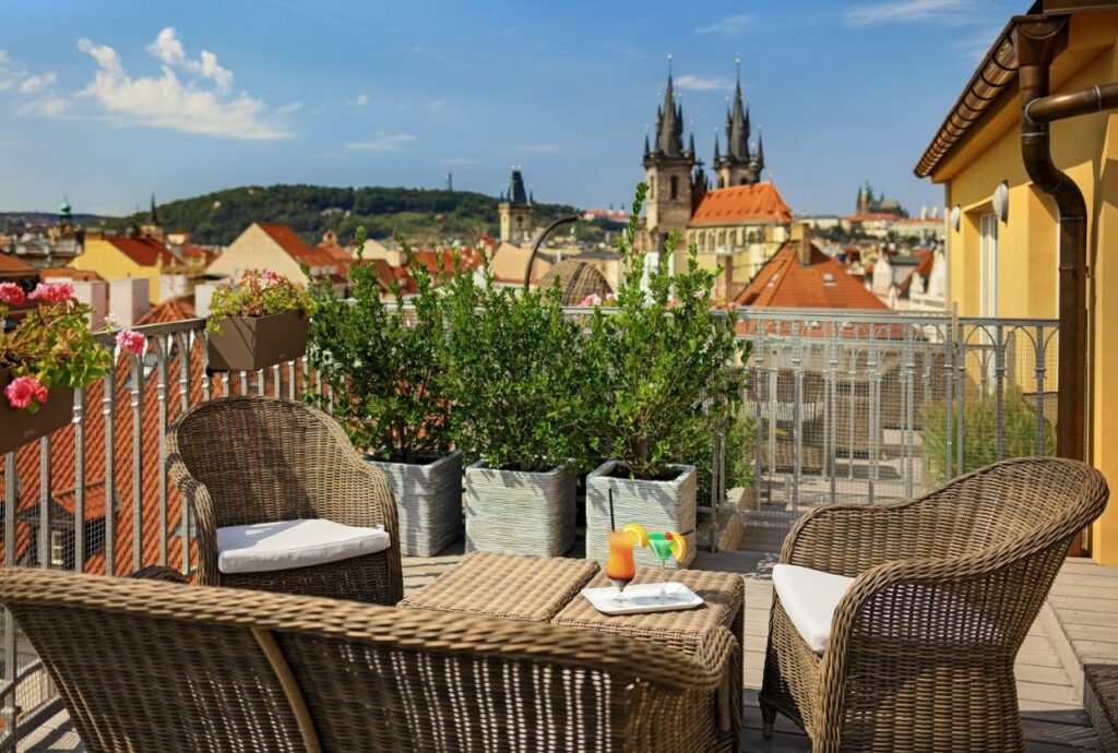 Patio with seating and city views at the Grand Hotel Bohemia in Prague.