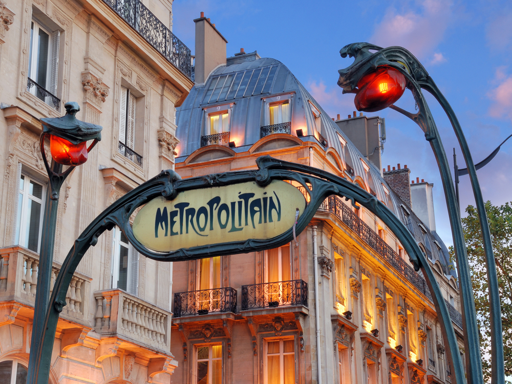 Metropolitain sign over a metro stop in Paris at sunset.